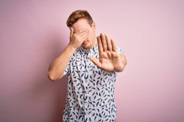 Genç, yakışıklı, yaz gömleği giyen, pembe arka planda dikilen, gözleri ellerle kaplayan, hüzünlü ve korku dolu ifadelerle jest yapan genç bir adam. Utanç verici ve olumsuz bir kavram..