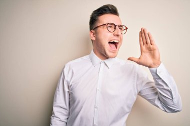 Genç yakışıklı iş adamları gözlük takıyor ve seçkin gömlekler giyip izole arka planda avazı çıktığı kadar bağırıyor ve ağızdan ağıza bağırıyorlardı. İletişim konsepti.