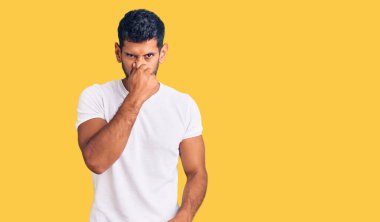 Gündelik kıyafetler giyen genç latin adam pis ve iğrenç bir koku alıyor, dayanılmaz bir koku, nefesini burnunda tutuyor. Kötü kokuyor. 