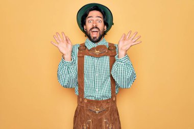 Almanya festivali için geleneksel Alman Ekim Festivali kıyafeti giyen genç yakışıklı adam çılgın ve başarısını kollarını kaldırarak ve gözlerini açarak heyecanla haykırarak kutluyor. Kazanan konsept