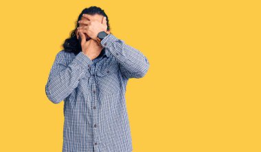 Genç Arap adam gündelik giysiler giyip gözleri ve ağzı elleriyle kapatmış, şaşırmış ve şok olmuş. duygu gizleme 