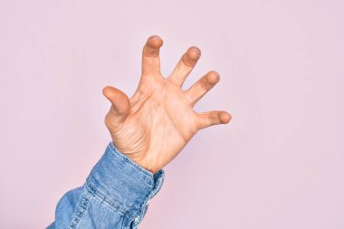 İzole edilmiş pembe arka planda parmaklarını gösteren beyaz bir gencin eli parmaklarıyla saldırganlaştırıyor ve korkutuyor. Şiddet ve hüsranla.