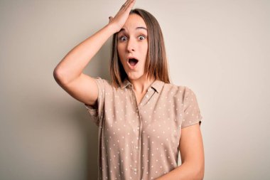 İzole edilmiş beyaz arka plan üzerinde duran sıradan bir gömlek giyen genç ve güzel bir kadın hata sonucu el ele tutuşarak şaşırdı. Hatayı hatırla. Unuttum, kötü hafıza konsepti.