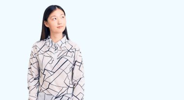 Genç, güzel, Çinli bir kadın. Sıradan bir tişört giyiyor. Gülümsüyor, yan tarafa bakıyor ve düşünüyor.. 