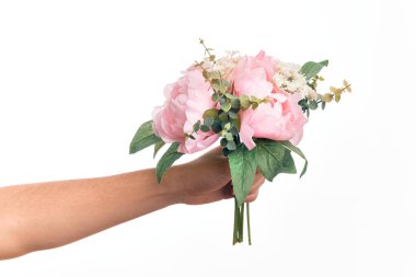 Beyaz arka plan üzerinde doğal çiçek buketi tutan beyaz bir adamın eli.