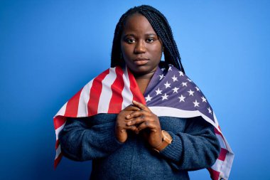 Genç, vatansever, Afro-Amerikan ve örgülü kadın. Birleşik Devletler bayrağı takıyor.