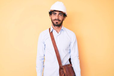 Kıvırcık saçlı, ayılı, mimar şapkalı, yüzünde ciddi bir ifade olan yakışıklı bir genç. Basit ve doğal bir şekilde kameraya bakıyorsun.. 