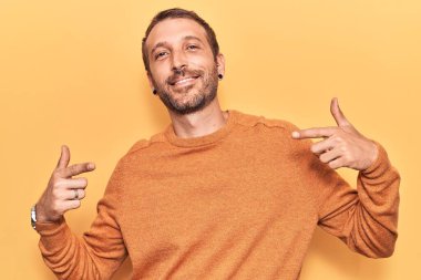 Gündelik kıyafetler giyen, kendine güveni olan, kendini gururlu ve mutlu gösteren genç yakışıklı bir adam.. 