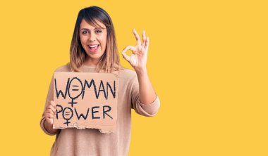 Genç, güzel bir kadın elinde güçlü bir pankart tutuyor. Parmaklarıyla imza atıyor, gülümsüyor. Mükemmel bir sembol. 