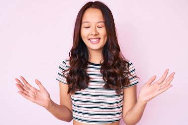 Genç, güzel Çinli kız, gündelik kıyafetler giyip başarıyı kutluyor. Kolları havada, gözleri kapalı, heyecanlı çığlıklar atıyorlar. Kazanan konsept 