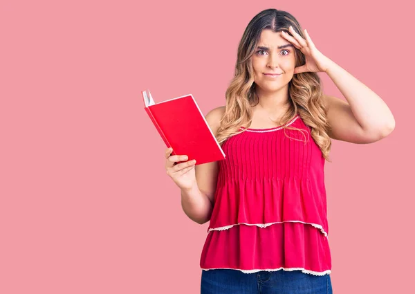 Joven Mujer Caucásica Sosteniendo Libro Estresado Frustrado Con Mano Cabeza — Foto de Stock