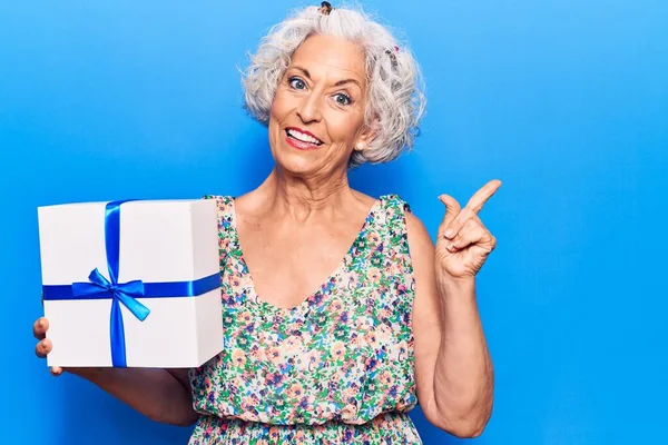 Senior Mulher Cabelos Grisalhos Segurando Presente Sorrindo Feliz Apontando Com — Fotografia de Stock