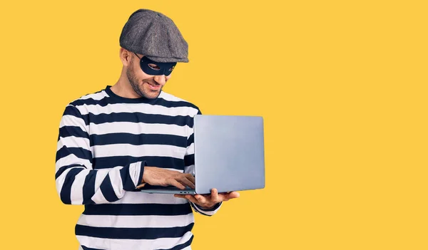 Jonge Knappe Man Draagt Inbraak Masker Met Behulp Van Laptop — Stockfoto