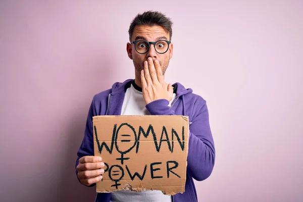 Young handsome man asking for women rights holding banner with woman power message cover mouth with hand shocked with shame for mistake, expression of fear, scared in silence, secret concept