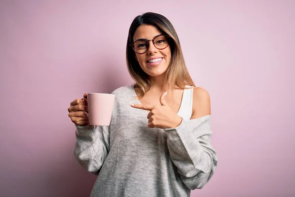 Νεαρή Όμορφη Μελαχρινή Γυναίκα Φορώντας Γυαλιά Πίνοντας Ροζ Κούπα Καφέ — Φωτογραφία Αρχείου
