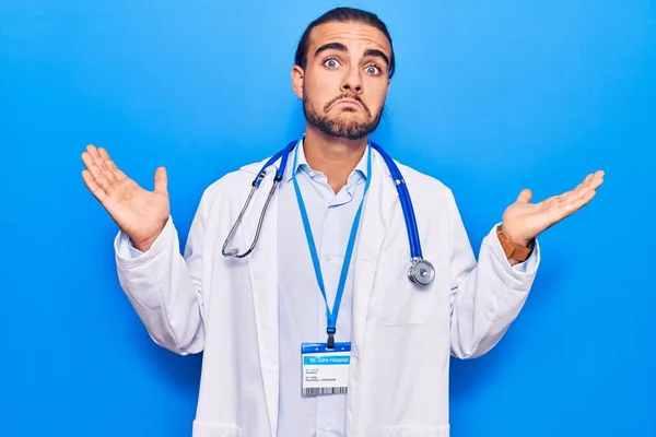 Jovem Homem Bonito Vestindo Casaco Médico Estetoscópio Sem Noção Confundido — Fotografia de Stock