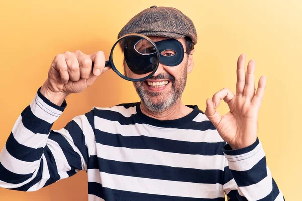 Middle Age Handsome Burglar Man Searching Using Magnifying Glass Yellow — Stock Photo, Image
