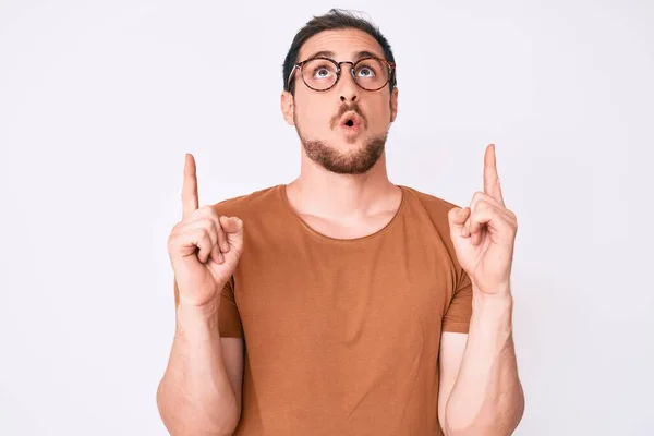 Joven Hombre Guapo Con Ropa Casual Gafas Asombrado Sorprendido Mirando —  Fotos de Stock