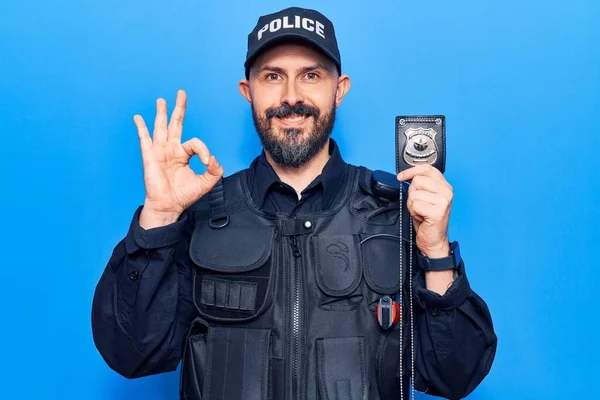 Jovem Bonito Homem Vestindo Polícia Uniforme Segurando Arma Fazendo Sinal — Fotografia de Stock