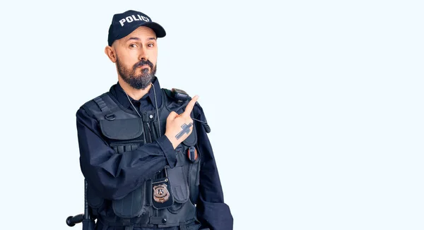 Mladý Pohledný Muž Policejní Uniformě Ukazuje Ukazováčkem Stranu Reklamou Vážnou — Stock fotografie