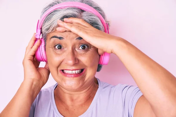 Senior Hispanic Woman Listening Music Using Headphones Stressed Frustrated Hand — Stock Photo, Image