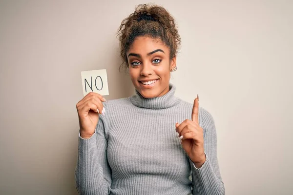 アフリカ系アメリカ人の少女のメモ用紙を保持しない言葉否定的なメッセージと驚きでアイデアや質問を指差す指で幸せな顔 ナンバーワン — ストック写真