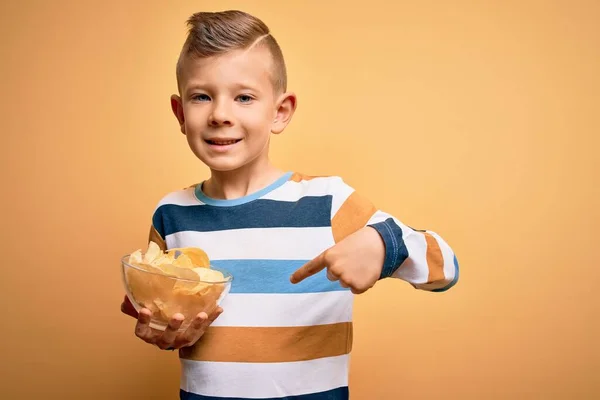 Młody Biały Dzieciak Nieogrzewane Chipsy Ziemniaczane Żółtym Tle Zaskakującą Twarzą — Zdjęcie stockowe