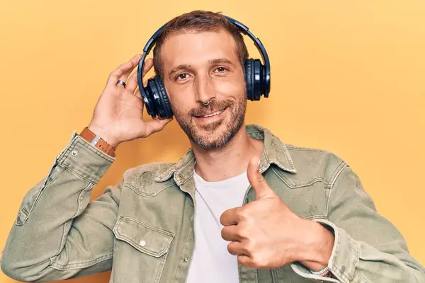 Νεαρός Όμορφος Άνδρας Ακούγοντας Μουσική Χρησιμοποιώντας Ακουστικά Χαμογελώντας Χαρούμενος Και — Φωτογραφία Αρχείου