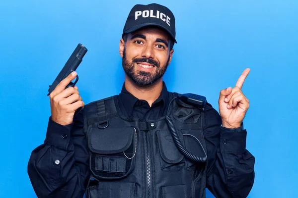 Mladý Hispánec Policejní Uniformě Šťastně Usmívá Ukazuje Rukou Prstem Stranu — Stock fotografie