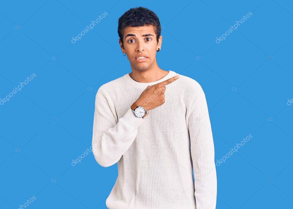 Young african amercian man wearing casual clothes pointing aside worried and nervous with forefinger, concerned and surprised expression 