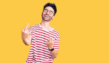 Young hispanic man wearing casual clothes showing middle finger doing fuck you bad expression, provocation and rude attitude. screaming excited 