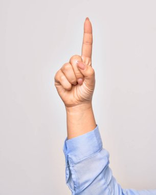 Beyaz arka plan üzerinde gerilmiş işaret parmağıyla yumruk sembolü çizen beyaz bir kadının eli.