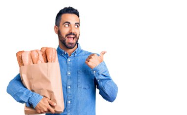 Yanında ekmek olan, ağzı açık gülümseyen genç İspanyol bir adam. 