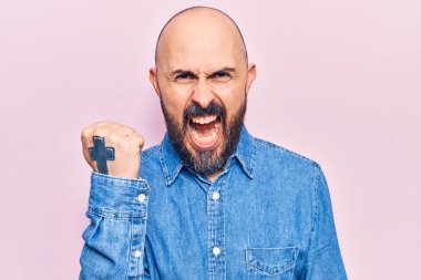 Genç, yakışıklı bir adam, kızgın ve kızgın. Öfkeyle bağırırken yumruğunu sallıyor ve öfkeleniyor. öfke ve agresif konsept. 