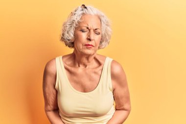 Yaşlı gri saçlı kadın, hazımsızlık, acı verici bir hastalık ve midesi kötü hissettiği için günlük kıyafetler giyiyor. Ağrı kavramı. 