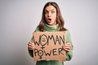Kadın iktidarı ve hakları için protesto pankartı tutan genç sarışın kız. Şok olmuş, korkmuş ve korku ifadesinden heyecanlanmış.