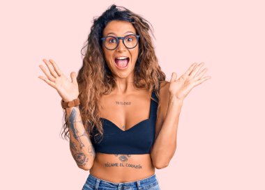 Sıradan kıyafetler giyen ve gözlüklü genç İspanyol kadın çılgın kutlamalar yapıyor ve kollarını kaldırıp heyecanla haykırarak başarı için hayrete düşüyor. Kazanan konsept 