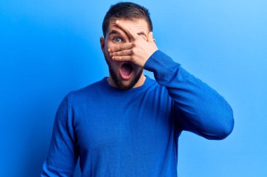 Genç yakışıklı adam, sıradan bir süveter giyiyor. Şoka giriyor, yüzünü ve gözlerini eliyle kapatıyor, parmaklarından bakıyor. 