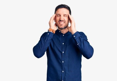 Genç, yakışıklı bir adam, elleri kafasında, rahat bir gömlek giyiyor. Stres yüzünden baş ağrısı çekiyor. migren ağrısı. 