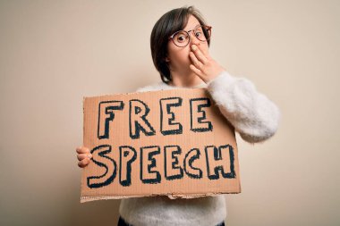 Genç Down sendromlu kadın, elinde iletişim hakları için ifade özgürlüğü bayrağı tutuyordu. Ağzı, hata üstüne utanç, korku ifadesi, sessizlikten korkmak, gizli bir konsept.