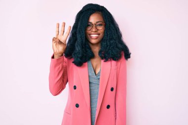 İş ceketi ve gözlük takan güzel Afrikalı kadın üç numaralı parmaklarını gösterip işaret ederken kendinden emin ve mutlu bir şekilde gülümsüyor.. 