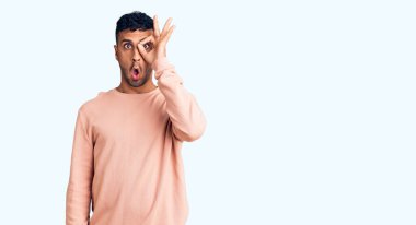 Gündelik kıyafetler giyen genç İspanyol adam şaşırmış yüz ifadesiyle şok olmuş, parmaklarından bakan gözler. İnançsız ifade. 
