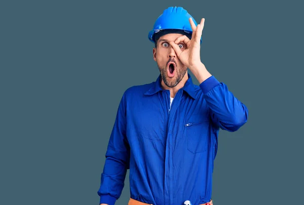 Ung Stilig Man Klädd Arbetare Uniform Och Hatt Pekar Ner — Stockfoto