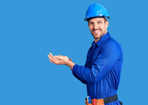 Jovem Bonito Homem Vestindo Trabalhador Uniforme Hardhat Convidando Para Entrar — Fotografia de Stock