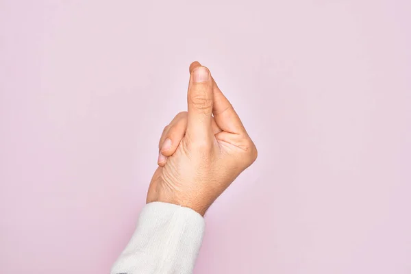 孤立したピンクの背景の上に指を示す白人青年の手親指の指で空白のスペースを保持 ビジネスと広告 — ストック写真