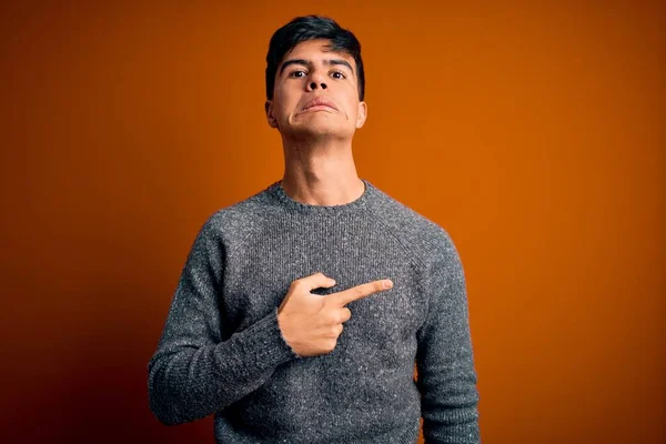 Jovem Homem Bonito Vestindo Camisola Casual Sobre Fundo Laranja Isolado — Fotografia de Stock