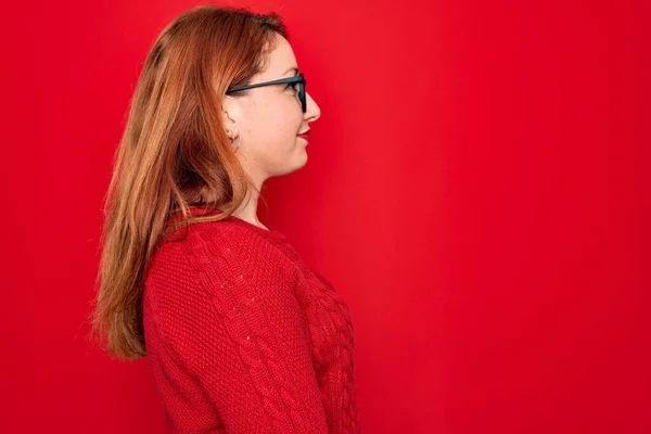 Joven Hermosa Pelirroja Con Suéter Casual Gafas Sobre Fondo Rojo — Foto de Stock