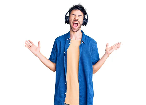 Jovem Hispânico Ouvindo Música Usando Fones Ouvido Celebrando Louco Louco — Fotografia de Stock