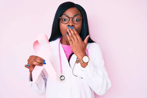 아프리카계 미국인 여성이 청진기를 손으로 코팅하는 분홍색 리본을 실수로 충격을 — 스톡 사진