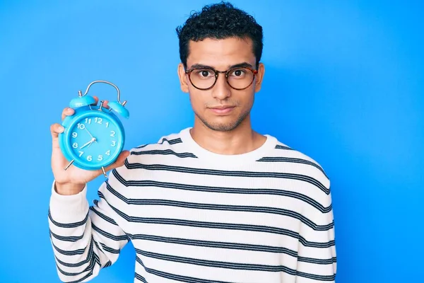 Young Handsome Hispanic Man Holding Alarm Clock Thinking Attitude Sober — Stock Photo, Image